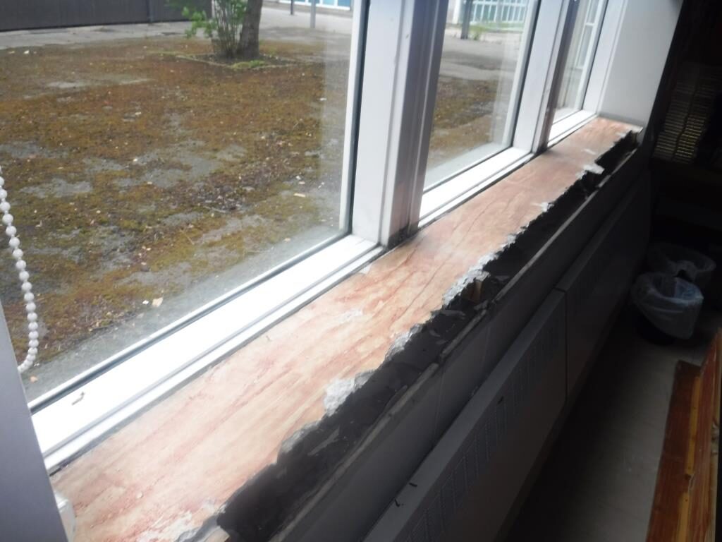 Asbestos insulation board below a window sill