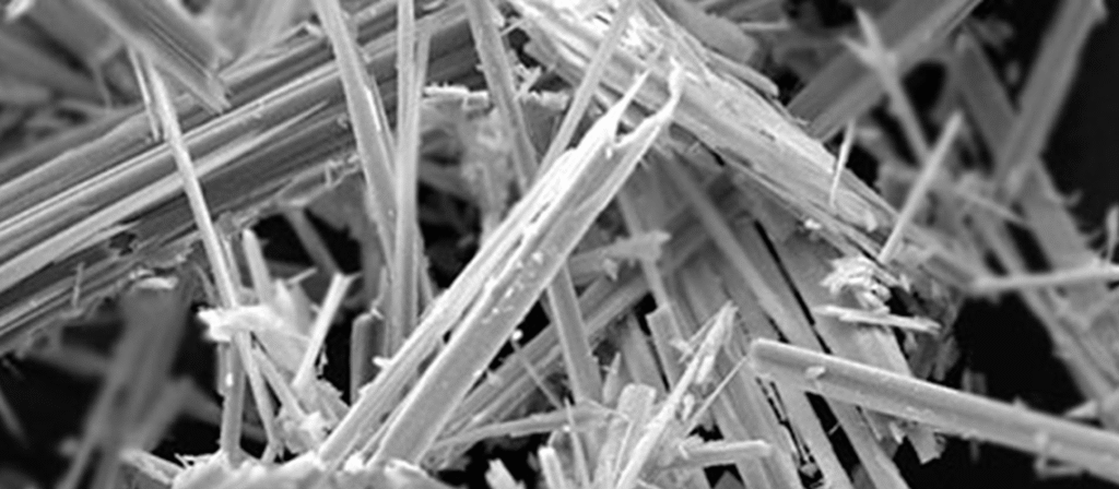 Microscopic view of raw amphibole asbestos fibres showing needle-like crystalline structure.